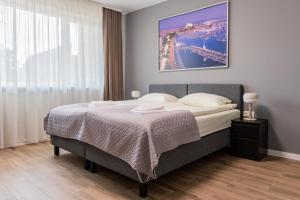 a bedroom with a bed with a picture on the wall at Svečių namai Imperija in Šiauliai