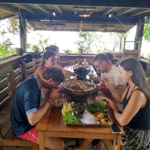 a group of people sitting around a table eating food at Don Falang Homestay- Private Island in Don Det +39 photos