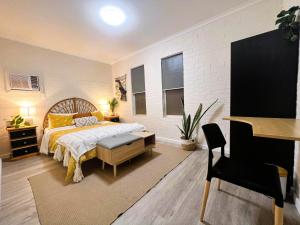 a bedroom with a bed and a desk and a piano at Stylish 3 Bedroom Apartment - South Hedland in South Hedland