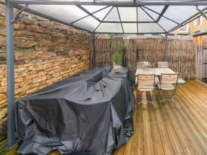 a covered patio with a table and chairs and a stone wall at Holiday Home - Entre Gaume et Ardenne in Florenville +33 photos