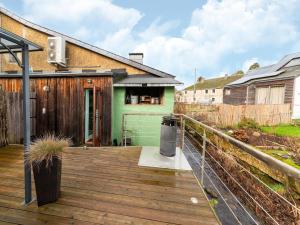a wooden deck with a trash can on a house at Holiday Home - Entre Gaume et Ardenne in Florenville