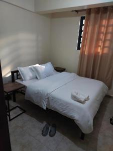 Un dormitorio con una cama con sábanas y almohadas blancas. en 1 bedroom Homabay, en Homa Bay