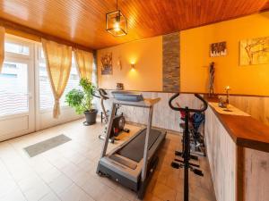 a gym with a treadmill in a room with yellow walls at Holiday Home - Entre Gaume et Ardenne in Florenville