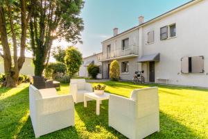 a garden with white chairs and a table in front of a building at Il Giardino Di Rebecca in Ferrara