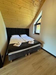 a bed in a room with a wooden ceiling at Osada na Jaworowej in Radawa +8 photos