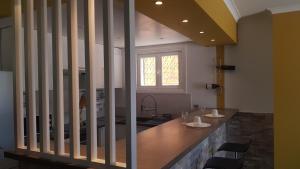 a kitchen with a counter with chairs and a sink at Maison Casa Milesa - Calme, Spa privatif sur demande, Parking securisé, à 12 min des plages in Nice