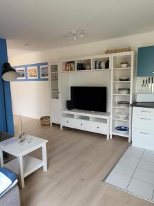 a living room with a white entertainment center with a television at Ferienwohnung Seewind in Überlingen