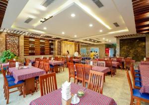 a restaurant with purple tables and chairs in a room at Crystal hotel by Ha My in Da Nang