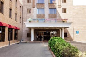 a building with a balcony on top of it at Best Western Plus Atakent Park Hotel in Almaty