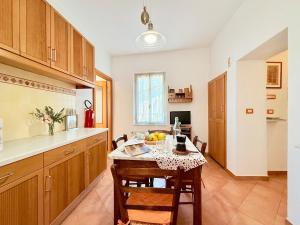 a kitchen with a table and some chairs in a room at DIMORA Concept-Virginia-Spacious Apartment 50m from the Beach in Finale Ligure