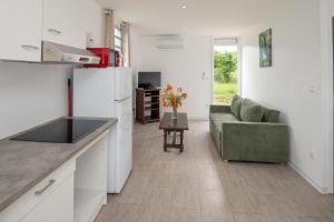 a kitchen and living room with a couch and a table at La fleur des îles - Maison Climatisé pour 4 in Morne-à-lʼEau +5 photos