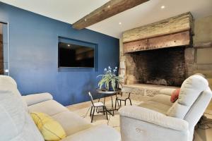 a living room with two couches and a fireplace at Castel Dolais - Magnifique Manoir pour 8p in Saint-Onen-la-Chapelle