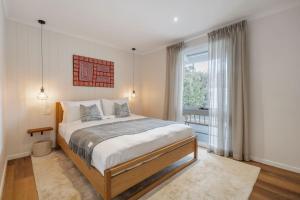 Un dormitorio con una cama y una ventana grande. en La Belle Vie - Boutique Country Escape near Wineries, en Red Hill