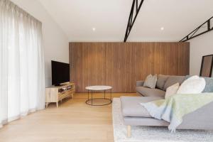 Una sala de estar con un sofá y un televisor. en La Belle Vie - Boutique Country Escape near Wineries, en Red Hill