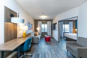 Una habitación de hotel con un escritorio y una cama. en Comfort Suites, en London