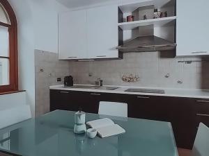 a kitchen with a glass table and a sink at Casa Stelvio in Stazzona