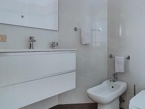 a white bathroom with a sink and a toilet at Casa Stelvio in Stazzona