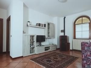 a living room with a television and a couch at Casa Stelvio in Stazzona
