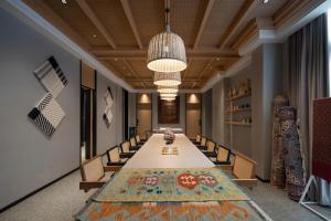 Koktokay可可托海的梦·非遗度假酒店的长长的会议室,配有长桌子和椅子