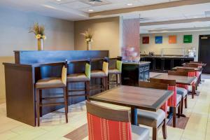a restaurant with wooden tables and chairs and a bar at Concord Suites by IHG in Concord