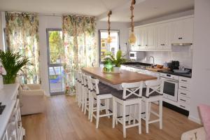 a kitchen with a large wooden table and white cabinets at Encanto de Oscos in San Martín de Oscos