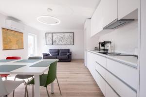 a kitchen and living room with a table and chairs at Villa Montês - Exclusive Apartments & Prime Location in Coja