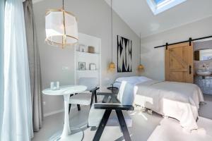 een witte slaapkamer met een bed en een tafel bij Slow living Suite 1 Oostkapelle in Oostkapelle