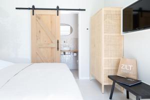 een slaapkamer met een bed en een schuifdeur bij Slow living Suite 1 Oostkapelle in Oostkapelle