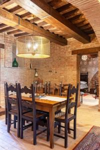 ein Esszimmer mit einem Holztisch und Stühlen in der Unterkunft Tuscany - Townhouse - Sleeps 18 - Garden near Lake in Gioiella