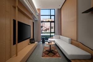 Koktokay可可托海的梦·非遗度假酒店的客厅里有一张白色沙发和一台电视