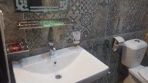 une salle de bain avec un lavabo blanc et des toilettes dans l'établissement Awan Guest House, à Dargai