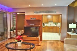 a living room with a tv and a table in it at Sofouli Suites in Nicosia