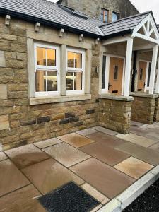 a brick house with windows and a patio at 4 Mulberry Green , Waterfoot , Rossendale, Lancs in Newchurch