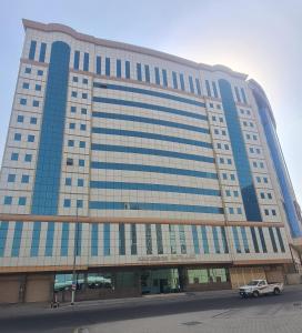 a car parked in front of a large building at فندق جوهرة الشروق in Az Zahrāʼ