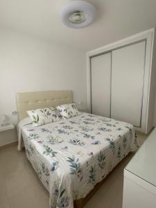 a bedroom with a bed with a floral bedspread at Cris Sol 205 in Arona +37 photos