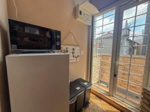 a room with a refrigerator with a microwave on top of it at ケイアイコンホテルズプロパンズ in Nagoya