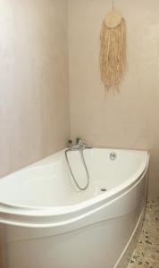 una vasca da bagno bianca seduta in bagno di La Cabane des Mouts- Piscine -Clim a Vendres-Plage