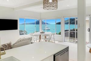 a kitchen and living room with a view of the ocean at Coastal Bliss at Shoal Bay in Shoal Bay