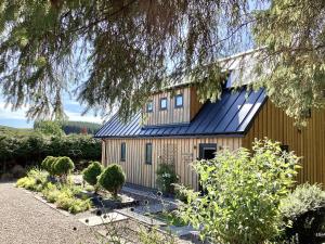 a wooden house with a blue roof at Larchwood Lodge in Ellon