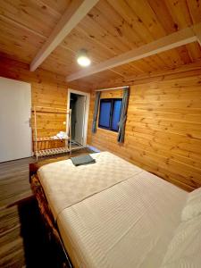 a bedroom with a large bed in a wooden room at Armoni Life Bungalov in Yanık
