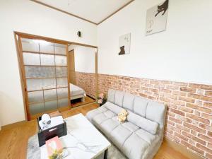 a living room with a couch and a brick wall at Nogata Relaxing Home C1 in Tokyo