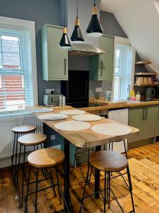 a kitchen with a large wooden table with stools at FRESH Flat in Leek, Staffordshire in Leek