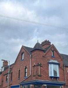 a red brick building with a black roof at FRESH Flat in Leek, Staffordshire in Leek