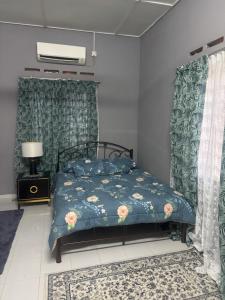 a bedroom with a bed with a blue comforter at Homestay Mr in Temerloh