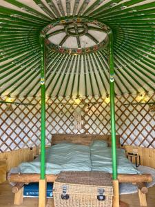 a bed in a yurt with a roof at Jurta Lilly in Volenice