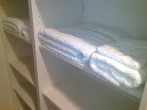 a closet with white towels on a shelf at bbrik in Alveringem
