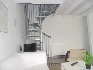 a living room with a spiral staircase in the background at bbrik in Alveringem