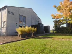 a building with potted plants on a wooden deck at bbrik in Alveringem