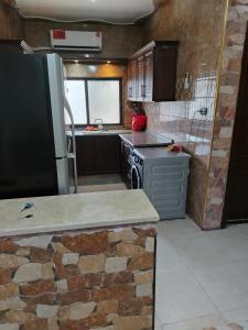 a kitchen with a refrigerator and a stove in it at الشقة الفاخرة الحديثة in Amman +6 photos