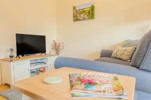 a living room with a couch and a coffee table at The Little Stable - Cosy 1 Bed Cottage in Burford in Swinbrook